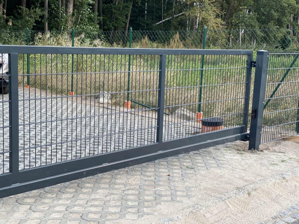 Moderne graue Metallzaun mit Schiebetor im Garten