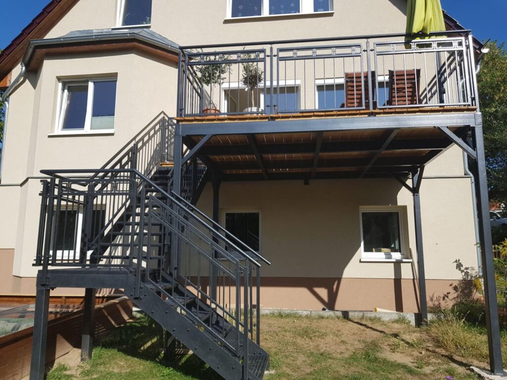 Haus mit Metallbalkon und Außentreppe im Garten