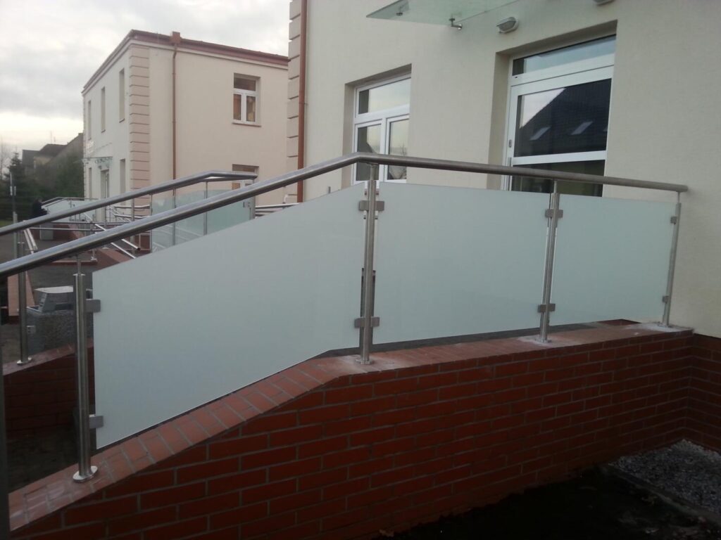 Moderne Glasgeländer an Gebäudeeingang mit Edelstahlrahmen