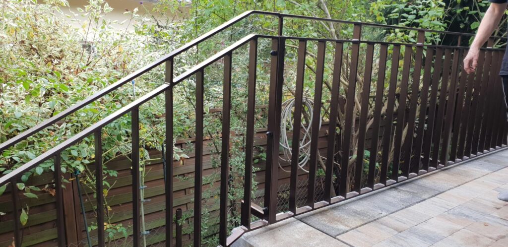 Balkongeländer aus Metall neben grünen Pflanzen