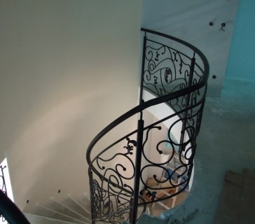 Spiraltreppe mit kunstvollem schwarzen Geländer im Innenraum