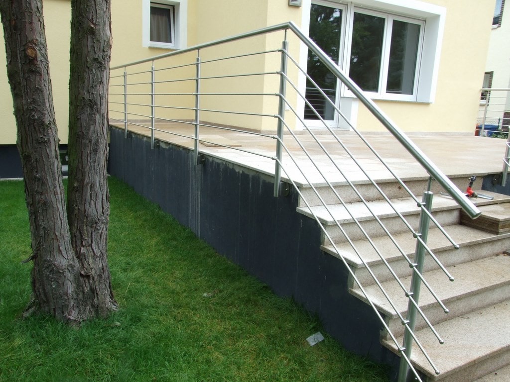 Moderne Edelstahlgeländer an Steintreppe eines Hauses