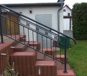 Metalltreppe mit modernem schwarzen Geländer am Haus