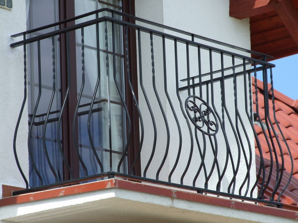 Schwarzes Schmiedeeisen-Balkongeländer an weißem Haus