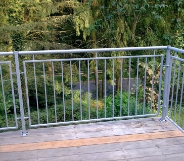 Metallgeländer auf Holzterrasse mit Waldblick