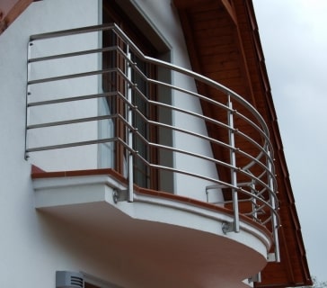 Moderner Edelstahlbalkon an einem weißen Wohnhaus