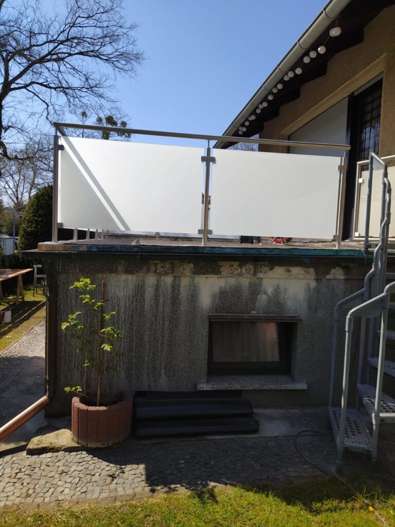 Moderner Balkon mit Glasgeländer an einem Haus