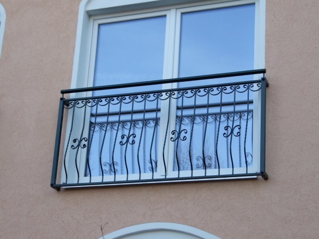 Schmiedeeisernes Balkongeländer vor Fenster