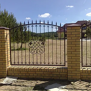 Schmiedeeiserner Zaun mit gelben Backsteinpfosten