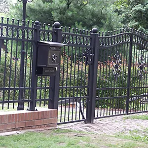 Schwarzes Metalltor mit Briefkasten im Garten
