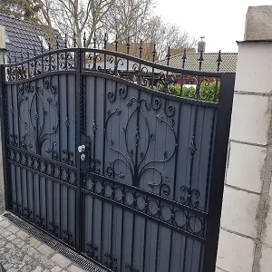 Schmiedeeisernes Tor mit dekorativem Muster vor Haus