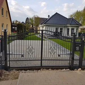 Modernes Haus mit schwarzem Metalltor und Einfahrt