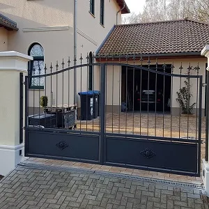 Schwarzes Metalltor vor einem modernen Haus