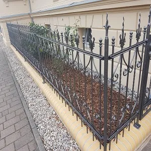 Schmiedeeiserner Zaun vor einem Gebäude