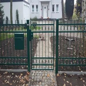 Grünes Metalltor vor modernem Wohnhaus